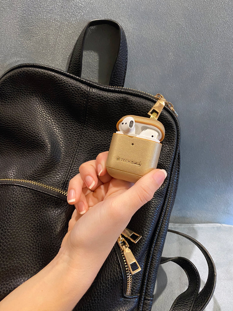 Mixed Metals AirPods Case clipped with metal clasp to a backpack 