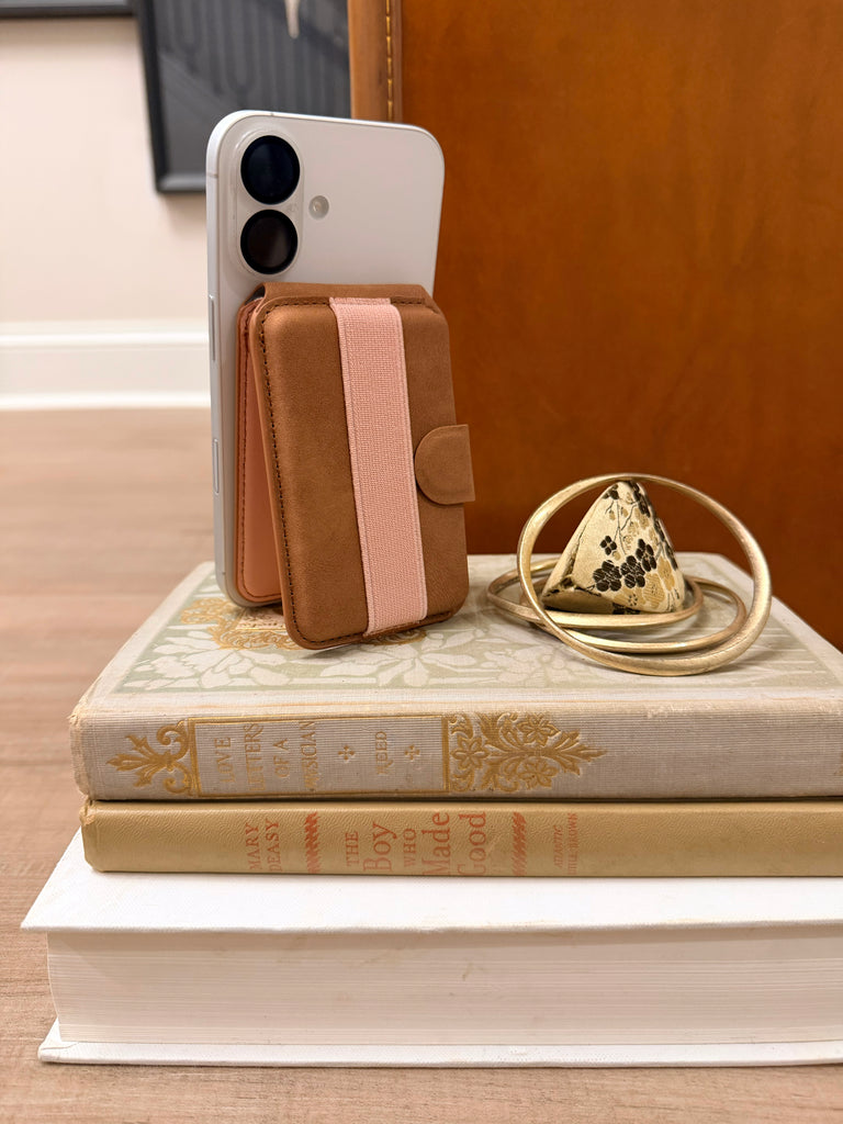 Tech Candy magnetic Back Pocket holds up to 4 cards, is a stand of your phone, and offers a back strap so you can hold your phone with ease. Shown in Saddlebag/Blush color.